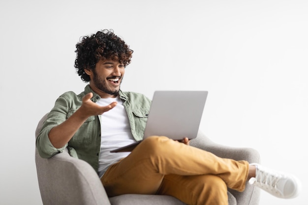 Foto cara oriental relaxado tendo chamada de vídeo usando computador