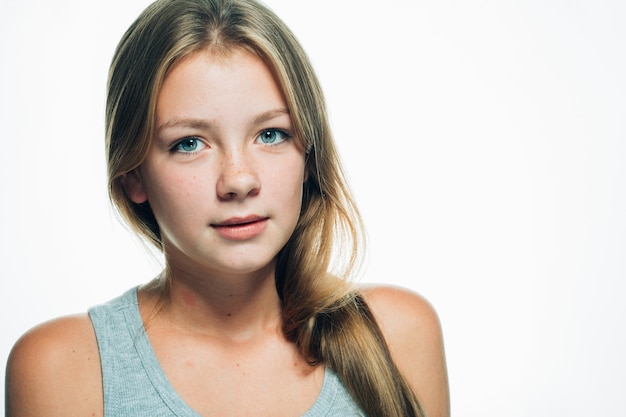 Cara de pecas de retrato femenino de mujer de niña adolescente aislado en blanco. Tiro del estudio.