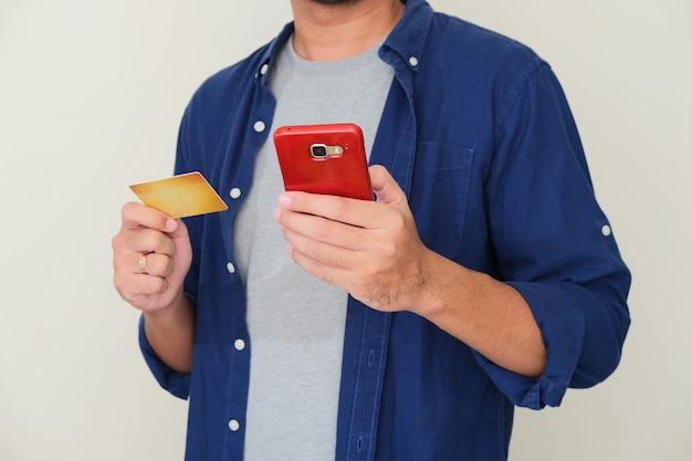 Cara recortada segurando um celular e um cartão em branco