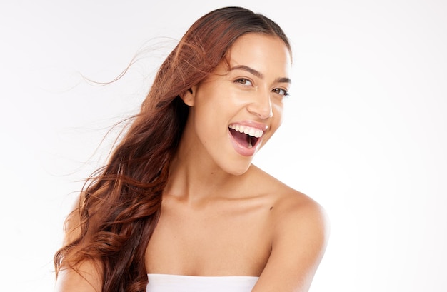 Cara de retrato y belleza con una mujer negra modelo en estudio sobre un fondo blanco para el cuidado de la piel Sonrisa feliz y cosméticos con una mujer joven atractiva posando para promover el cuidado natural del cabello