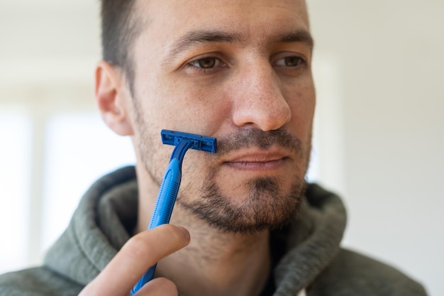 Cara sério, raspando a barba.