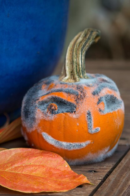 Cara sonriente en la calabaza en la mesa de madera