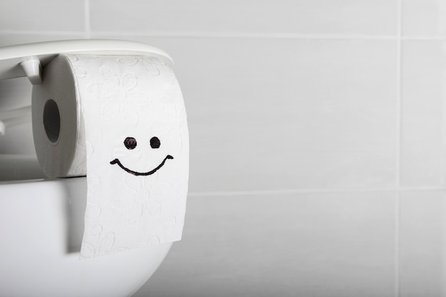 Cara sonriente en rollo de papel higiénico con espacio de copia
