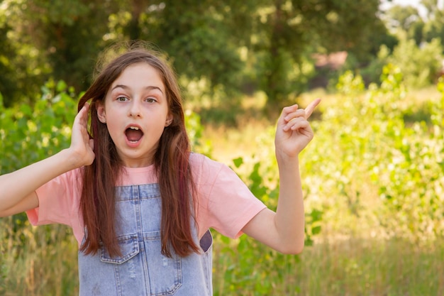 La cara de sorpresa de un niño. Niña de 11 años en el contexto del follaje en la temporada.