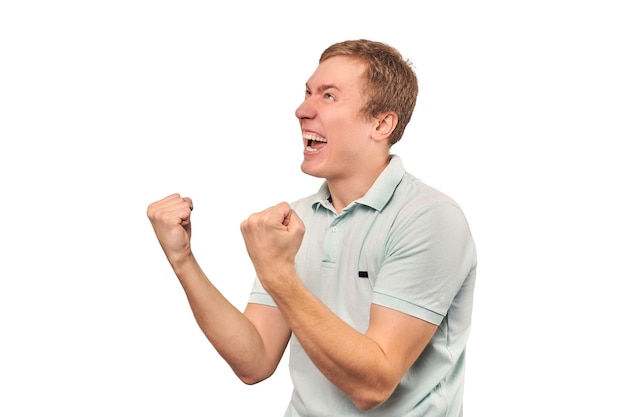 Cara sorridente bem-sucedida em camiseta menta se alegra com o sucesso do triunfo do fundo branco