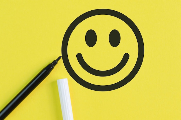 Cara sorridente desenhada em fundo amarelo Feedback do cliente e conceito de avaliação