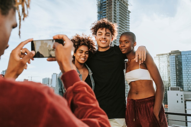 Cara tirando uma foto de seus amigos em um telhado