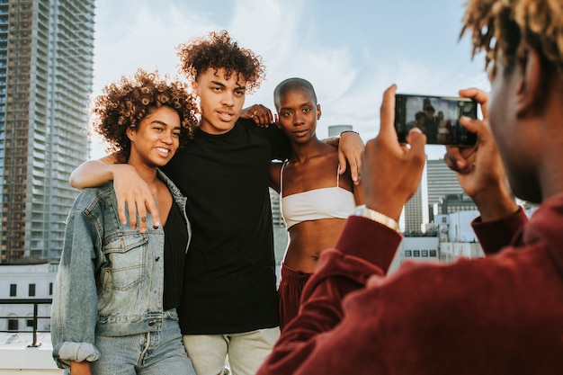 Cara tirando uma foto de seus amigos em um telhado