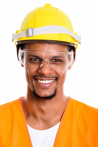 Cara de trabajador de la construcción hombre africano feliz sonriendo mientras usa gafas protectoras