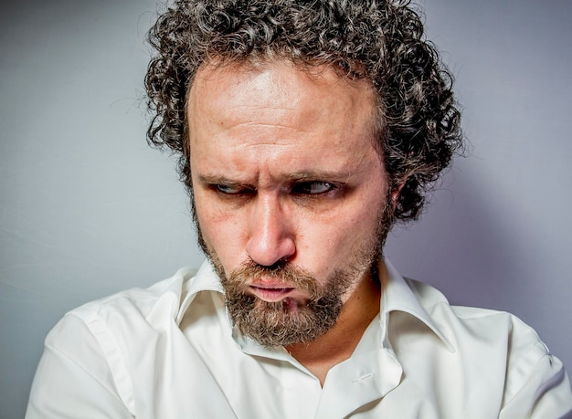 cara triste, hombre con expresión intensa, camisa blanca