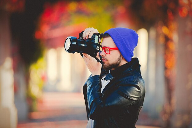 Cara, usando uma câmera para uma fotografia em um parque