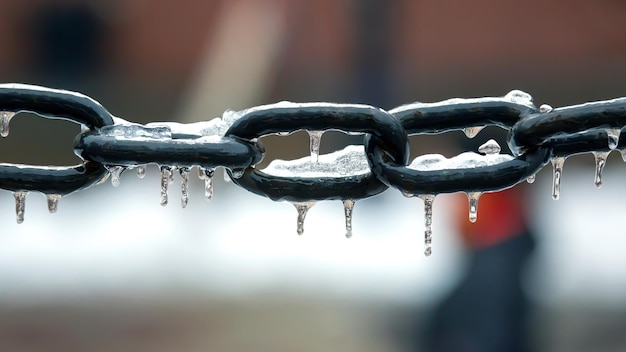 Carámbanos en una cadena de metal congelado temporada de invierno detalles interiores de la calle