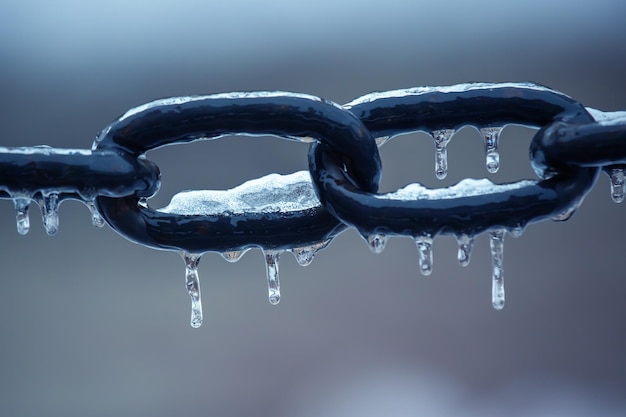 Carámbanos en una cadena de metal congelado temporada de invierno detalles interiores de la calle