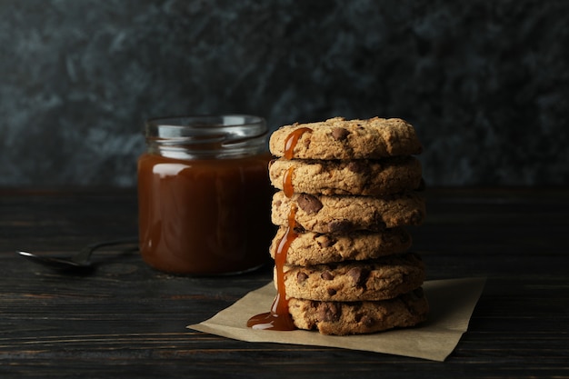 Caramelo, colher e biscoitos na mesa de madeira