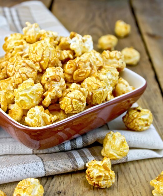 Caramelo de palomitas de maíz a bordo en cuenco de arcilla con servilleta