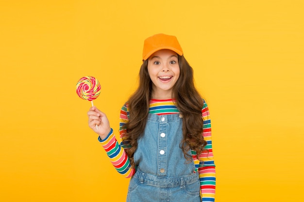 Caramelo de piruleta de niño feliz. niño divirtiéndose. concepto de tienda de dulces. optimista por naturaleza. dulce vida. infancia feliz. positivo y amistoso. Feliz Día del Niño. estilo hipster de niña pequeña. Me encantan las piruletas.