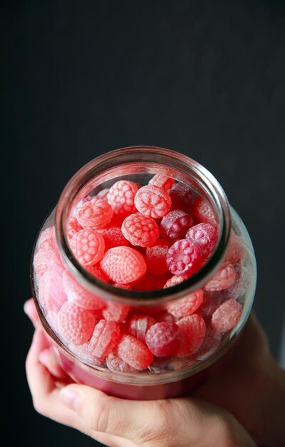 Caramelo rojo en un tarro de cristal con fondo negro