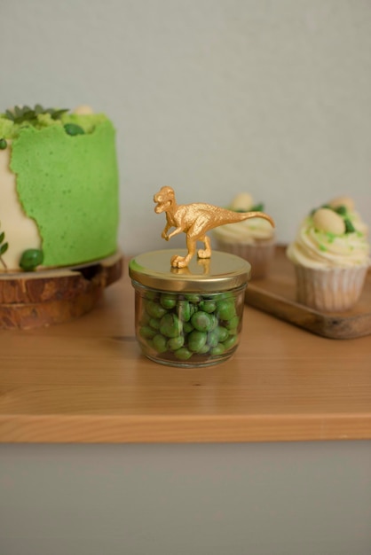 Caramelo en tarro de cristal, decorado con la figura de un dinosaurio dorado