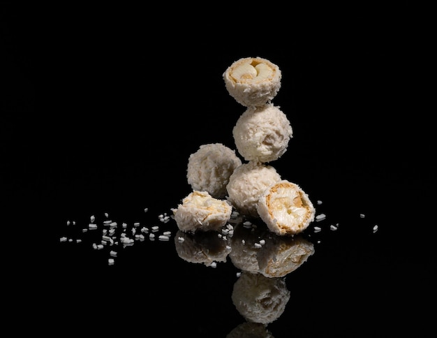 Caramelos blancos de Raffaello con almendras en un fondo negro