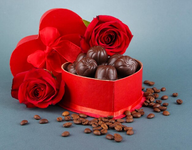 Caramelos de chocolate en caja de regalo, sobre fondo gris