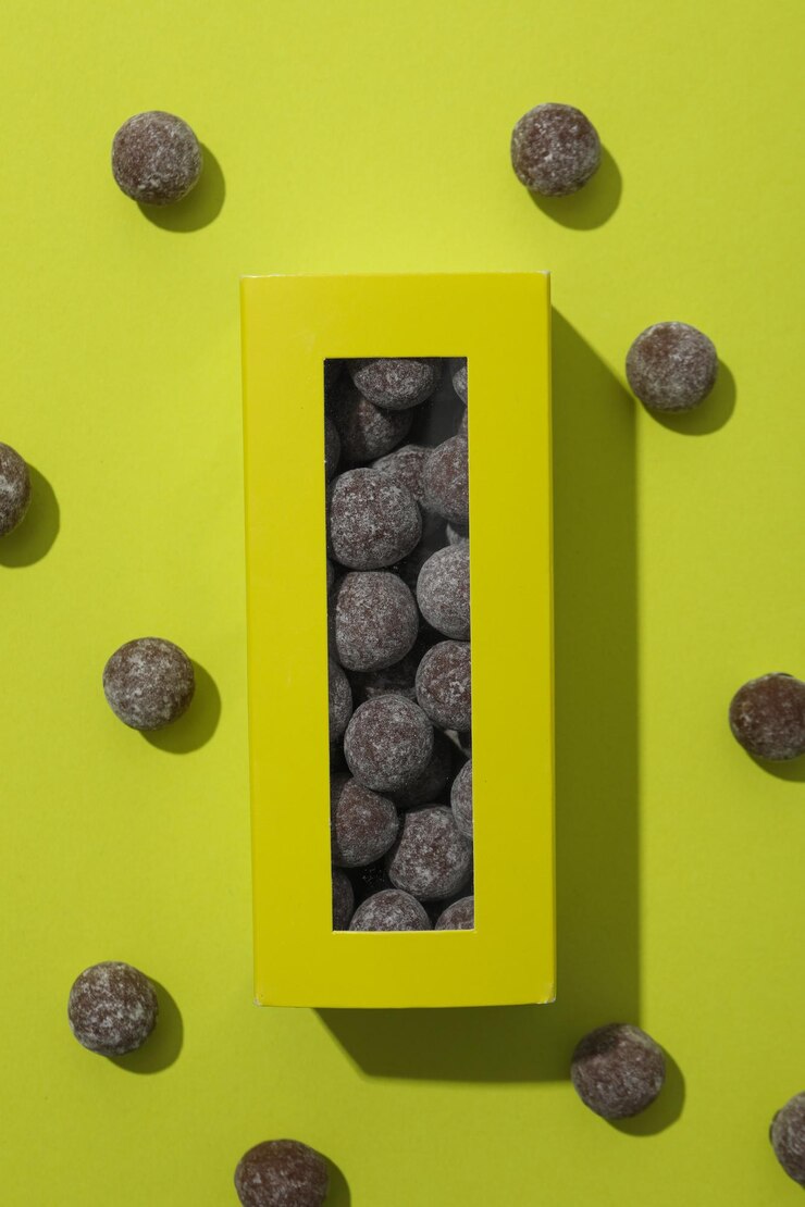 Caramelos de chocolate en caja y en la vista superior de fondo verde