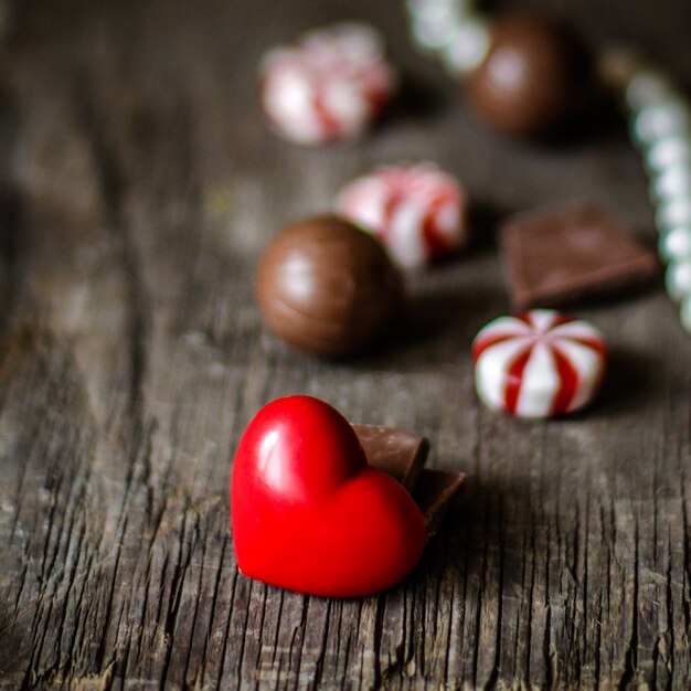 Foto caramelos de chocolate y decoración de corazón.