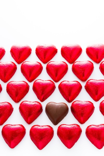 Caramelos de chocolate con forma de corazón envueltos en papel de aluminio rojo para el Día de San Valentín.