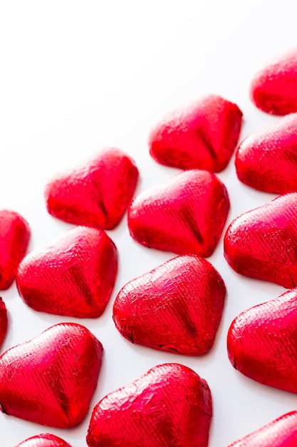 Caramelos de chocolate con forma de corazón envueltos en papel de aluminio rojo para el Día de San Valentín.