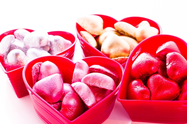 Caramelos de chocolate con forma de corazón envueltos en papel de colores para el Día de San Valentín.