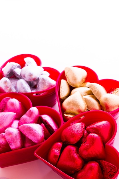 Caramelos de chocolate con forma de corazón envueltos en papel de colores para el Día de San Valentín.