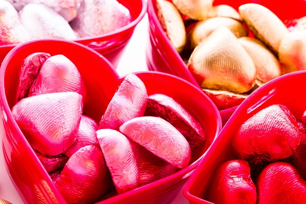 Caramelos de chocolate con forma de corazón envueltos en papel de colores para el Día de San Valentín.