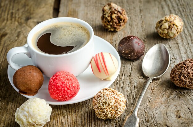 Caramelos de chocolate de lujo y taza de café.