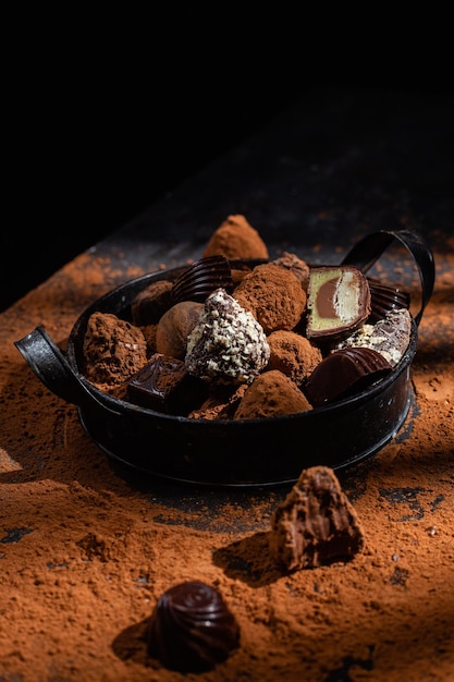 Caramelos de chocolate en un plato sobre un fondo oscuro Cacao