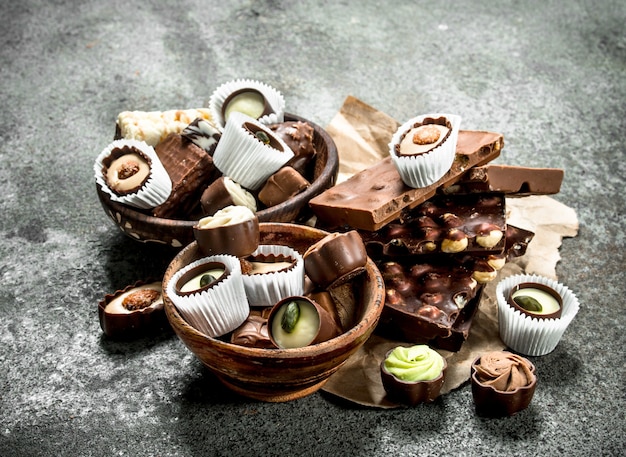Caramelos de chocolate en tazones. Sobre un fondo rústico.