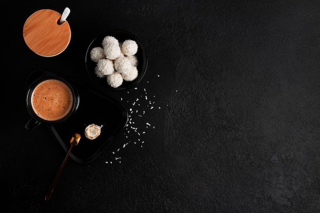 Caramelos de coco con nueces sobre fondo oscuro Raffaello sobre fondo negro Foto de alta calidad