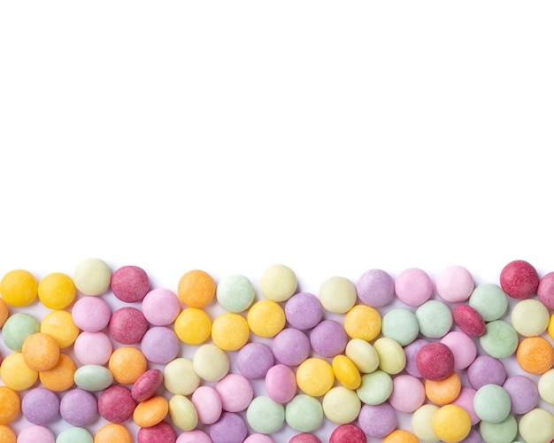 Caramelos de colores sobre fondo blanco con espacio de copia