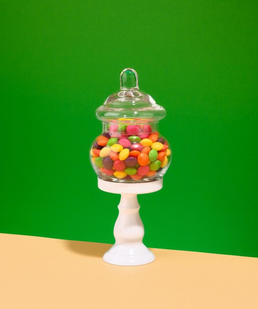 Foto caramelos coloridos y brillantes en un soporte blanco composición elegante para las vacaciones