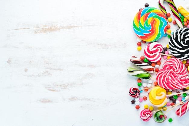 Caramelos coloridos gelatina y mermelada sobre un fondo blanco de madera Dulces Vista superior espacio de copia libre