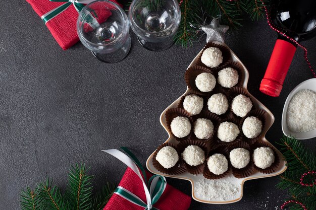 Caramelos dulces de coco rafaello servidos en plato como árbol de Navidad. Vista superior