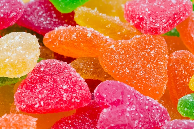 Caramelos de frutas de colores en azúcar en forma de corazones