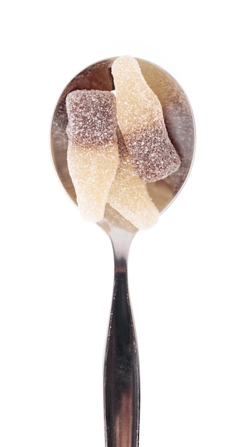 Caramelos de gelatina en cuchara aislado sobre un fondo blanco.