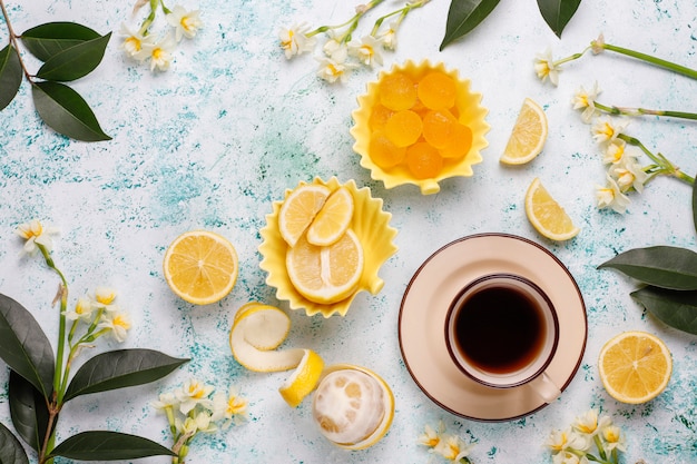 Caramelos de gelatina de limón con limones frescos sobre hormigón, vista superior