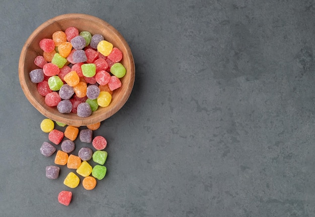 Caramelos de goma de colores sobre fondo de piedra con espacio de copia