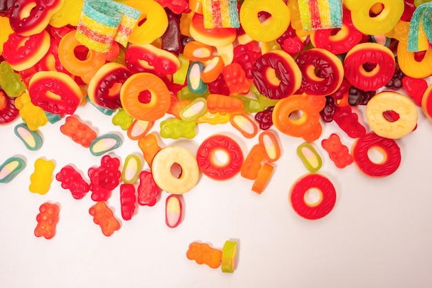 Foto caramelos gomosos de colores surtidos vista superior rosquillas de gelatina osos de gelatina aislados en un fondo blanco