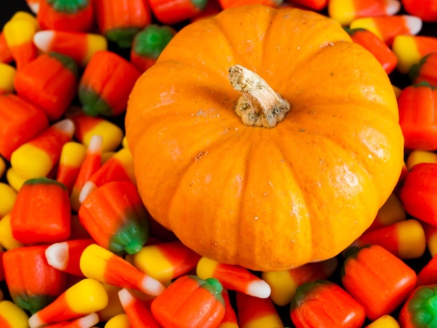 Caramelos de maíz y calabaza de Halloween sobre fondo negro.