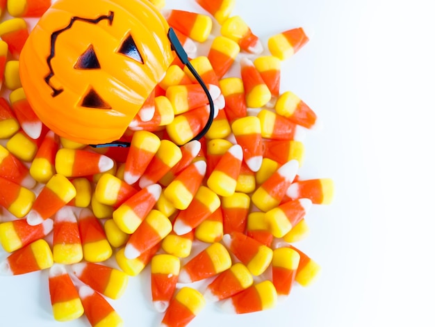 Foto caramelos de maíz dulce cayendo de la bolsa de golosinas de halloween.