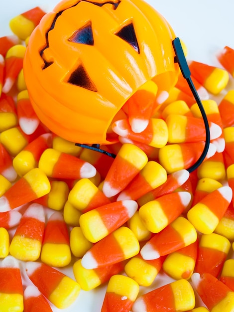 Foto caramelos de maíz dulce cayendo de la bolsa de golosinas de halloween.