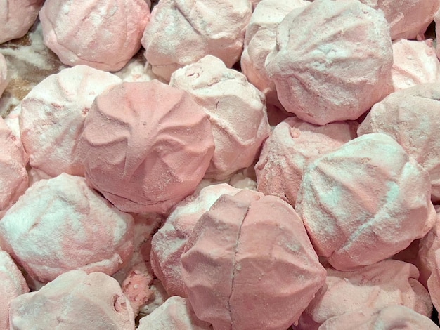 Caramelos de malvavisco de forma redonda acostados en una pila Dulces de color blanco y rosa