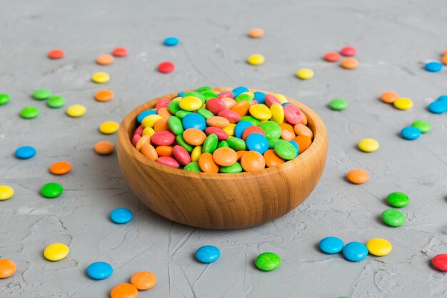 Caramelos multicolores en un cuenco en un fondo coloreado concepto de cumpleaños y vacaciones Vista superior con espacio de copia