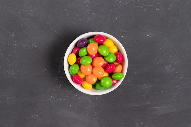 Foto caramelos redondos multicolores en un plato blanco